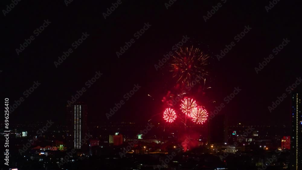 View of fireworks sparks explosions in the sky among tall buildings night city View of fireworks sparks explosions in the sky among tall buildings night city