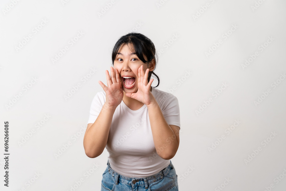 The portrait of beautiful young Asian woman is raising her hand up to her mouth for whisper or shout out gesture.. The portrait of beautiful young Asian woman is raising her hand up to her mouth for whisper or shout out gesture..