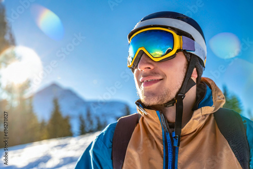 skieur souriant devant un paysage de montagne enneigée