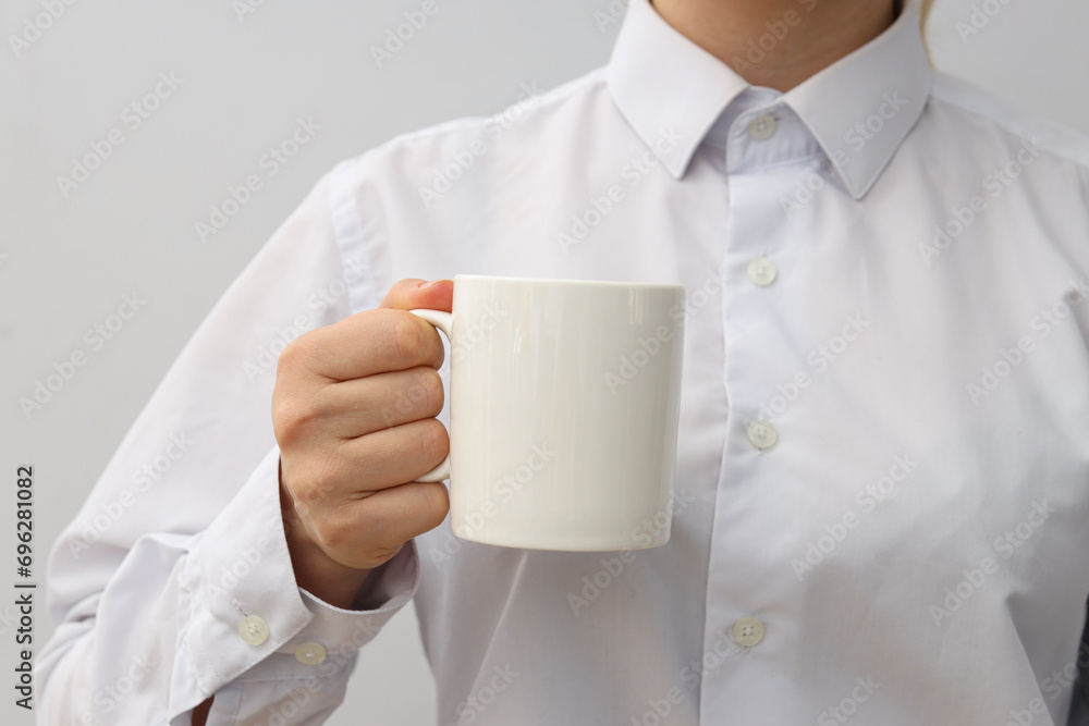 A woman holds a white cup in her hands A woman holds a white cup in her hands