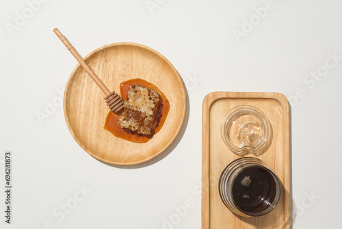 Honey is displayed on wooden trays with a minimalist white background. Honey contains antioxidant ingredients that help improve cholesterol and triglycerides.