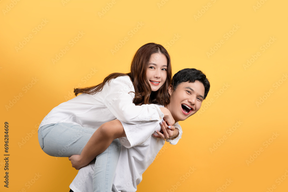 Cute Asian couple is proudly showing off their cheerful and happy expressions. He made the woman piggy-back ride. Cute Asian couple is proudly showing off their cheerful and happy expressions. He made the woman piggy-back ride.
