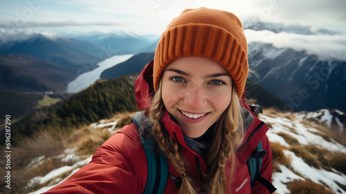 Young hiker beauty woman having fun taking selfie portrait on the top of mountain photo