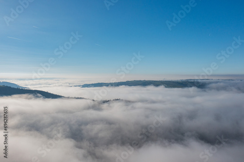 Aerial view above a sea of clouds with blue sky