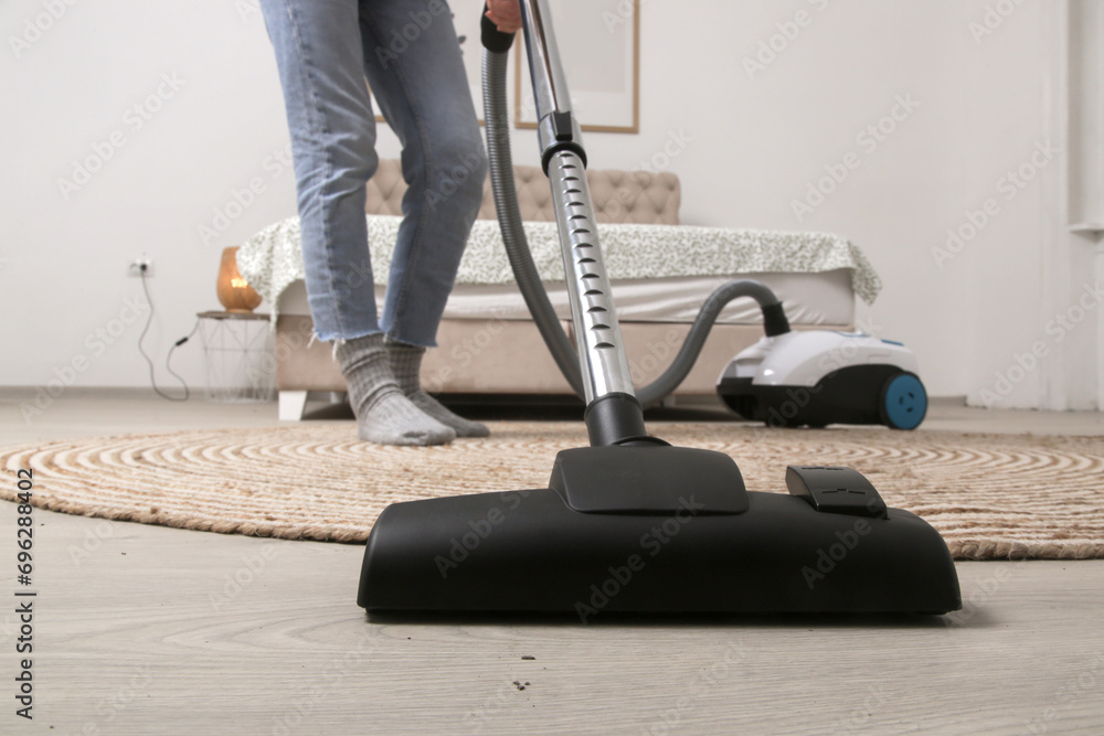 Fototapeta premium Housewife vacuuming the room, domestic life, apartment cleaning concept