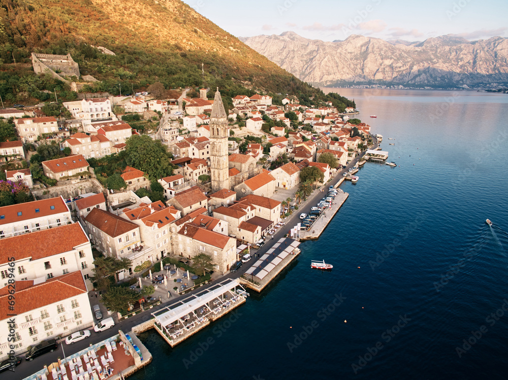 Perast promenade with outdoor restaurants on the piers by the sea. Montenegro. Drone