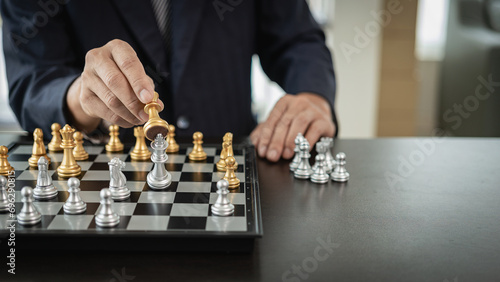 Photos Businessman is playing chess game, leading strategy planning, business leader concept and thinking of strategy plan about toppling the opposing team and analyzing the development for success