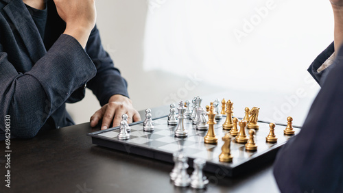 Businessman is playing chess game, leading strategy planning, business leader concept and thinking of strategy plan about toppling the opposing team and analyzing the development for success. photo