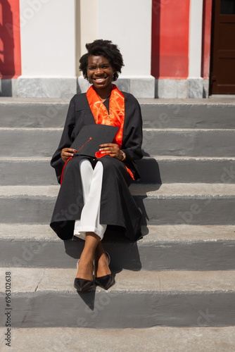 portrait of a beautiful African girl student in graduation uniform with a diploma in her hands
