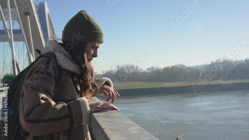 Depressed young woman and contemplating suicide, On the edge of a bridge with river below., Suicide and Major depressive disorder concept. Homeless female suffering after job loss. Homelessness issue photo