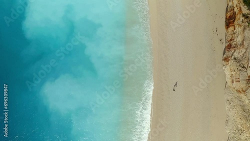 Drone aerial top view of couple walking on iconic Porto Katsiki beach in Lefkada island with turquoise water, in Greece photo