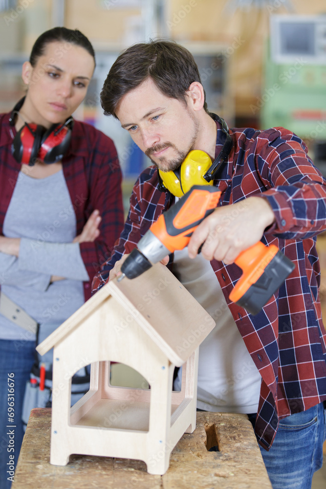 woman and man making a wood house model