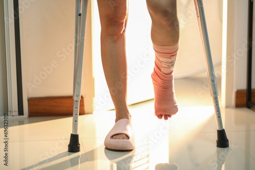 Close-up Young woman broken leg with crutches walking out from the toilet.