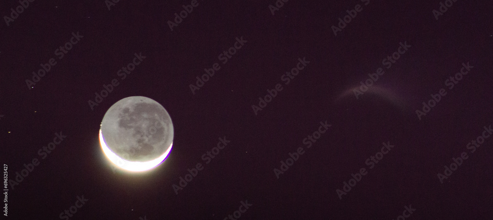 Obraz premium Waning crescent moon against a purple and black night sky.
