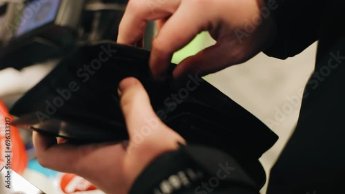 The man is rummaging in his wallet trying to find money. Close-up of hands with a wallet photo