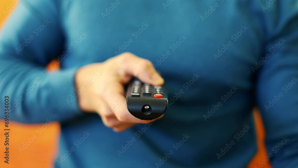 Watching TV and using remote controller. Hand of man with remote controller changing channels or opening apps on smart tv. concept of leisure and spending time in front of the TV boredom Watching TV and using remote controller. Hand of man with remote controller changing channels or opening apps on smart tv. concept of leisure and spending time in front of the TV boredom