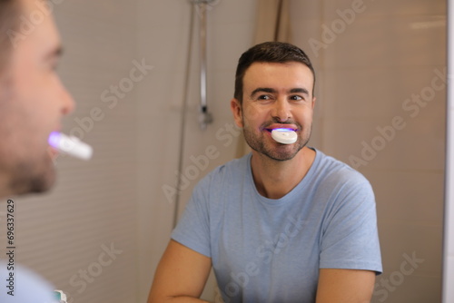 Man whitening  his teeth at home  photo