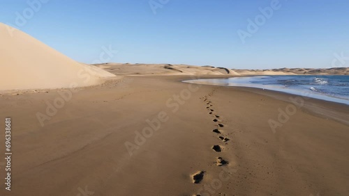 Beautiful serene sand dunes and beach with footprints in the sand. Where the Sahara desert meets the Atlantic Ocean, Lac Naila, National Park Kheniffis, Morocco. 4k natural landscape background footag