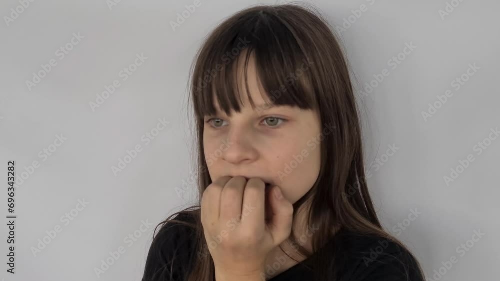Beautiful girl standing looks tense and nervous with hands in mouth and biting nails. Anxiety problem Beautiful girl standing looks tense and nervous with hands in mouth and biting nails. Anxiety problem