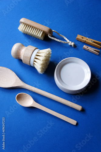 Zero waste concept. Eco-friendly kitchen tools, bamboo brush, wooden spoon, clothespin. Top view  flatlay, blue background