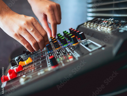Close-up of sound engineer hands adjusting control sound mixer in recording, broadcasting studio,Sound mixer. Professional audio mixing console, buttons, faders and sliders. sound check.