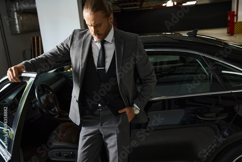 appealing elegant businessman with dapper style posing next to his car with hand in pocket © LIGHTFIELD STUDIOS