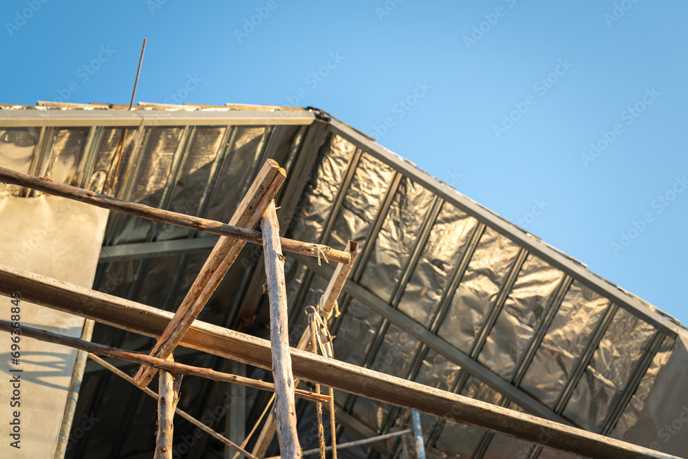 Obraz premium The under construction residential house with pre-casting concrete structure and wooden material scaffold frame. building industrial construction site, selective focus.