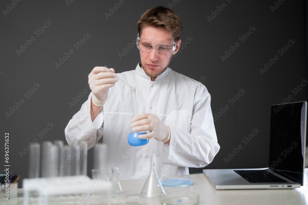 male scientist in white uniform working on a research in a laboratory male scientist in white uniform working on a research in a laboratory