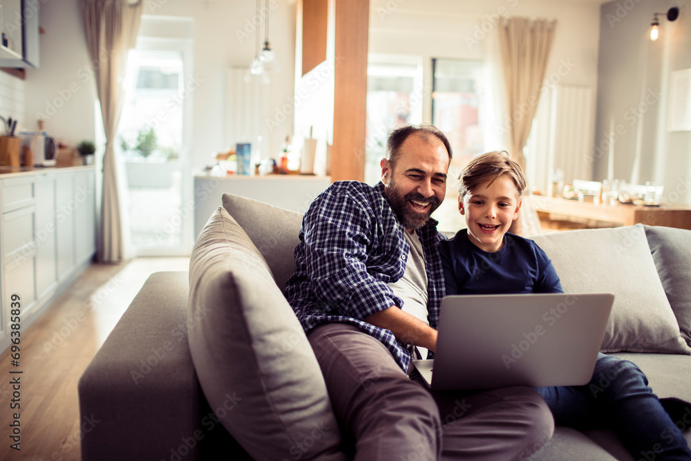 Father and son having fun with laptop at home Father and son having fun with laptop at home