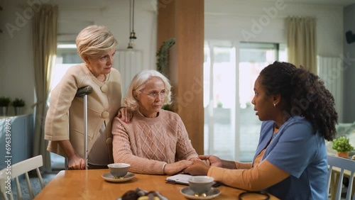 Senior women talking to caregiver at home photo