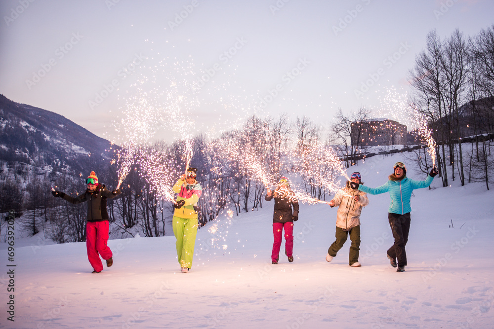 Group of snowboarders on winter holiday season having fun and bonding outdoors in the snow