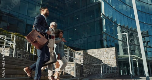 Business people, stairs and outdoor in city with conversation for travel, commute or walking to work. Employee, professional and colleague with briefcase, communication and happy on steps by building photo