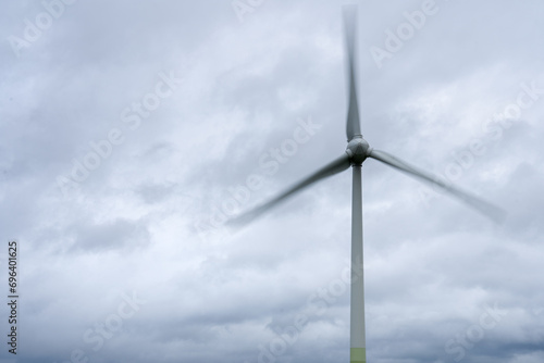 Windrad in Bewegung, Himmel mit Wolken ist gut zu sehen. Windenergie und Erneuerbare Energien Zeichen dieses Foto aus. 