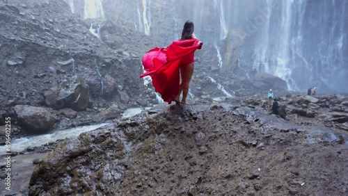 4k slow motion video. Tumpak Sewu in East Java, Indonesia with young woman in red dress, Video Shot photo