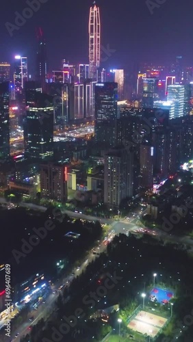 Illuminated Shenzhen City at Night. Futian District. China. Aerial View. Drone Flies Forward, Tilt Up. Reveal Shot. Vertical Video photo