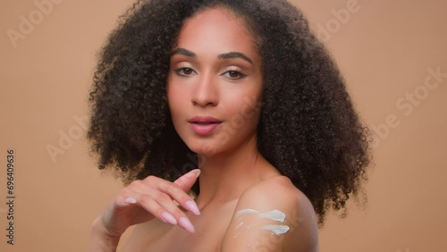 Beautiful pretty smiling woman African American girl with soft skin care attractive female apply body cream lotion organic natural cosmetic touch shoulder moisturizing skincare hydration sunscreen photo