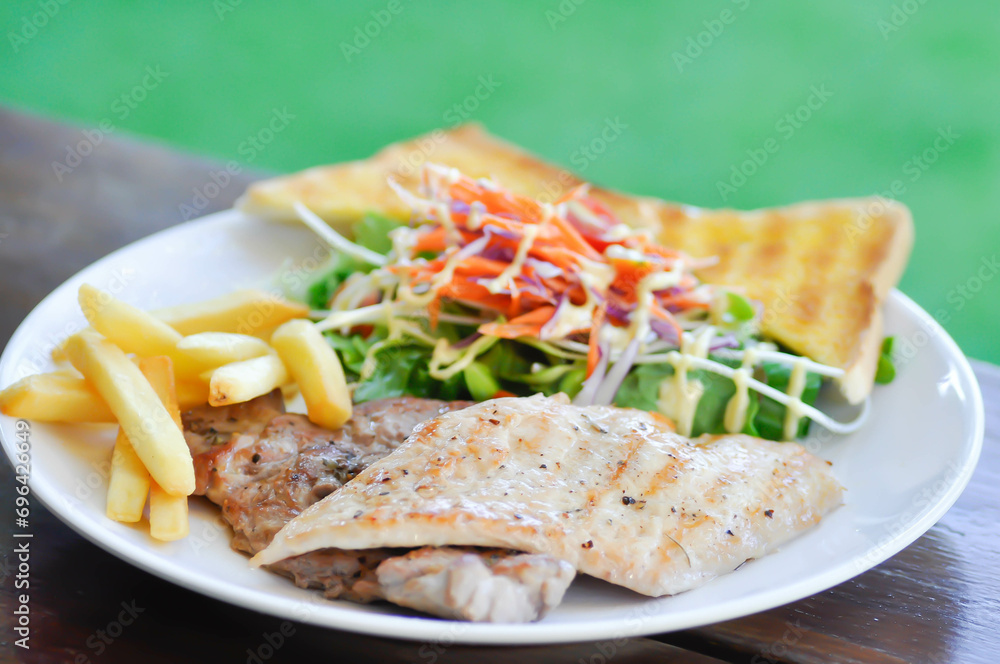 pork steak and chicken steak with French fries ,bread and salad or grilled pork and grilled chicken with fried potato pork steak and chicken steak with French fries ,bread and salad or grilled pork and grilled chicken with fried potato