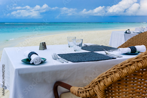 Papier peint Romantic table setting for two on the beach in front of turquoise ocean