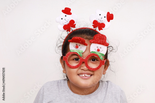 Portrait of asian little girl smiling and wearing christmas accessories. Isolated on white photo