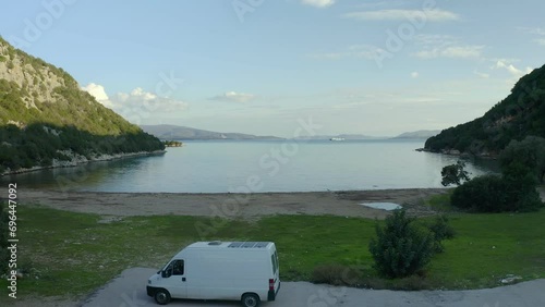 Drone aerial view of a camper van alone on Marathias wild beach in Greece photo