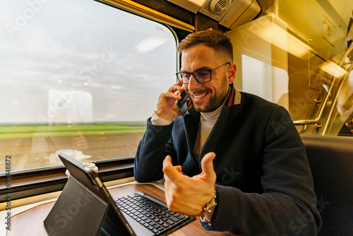 Commuter on his way to work using technology to catch up on his work load, he's using the commute time to have some call meetings photo