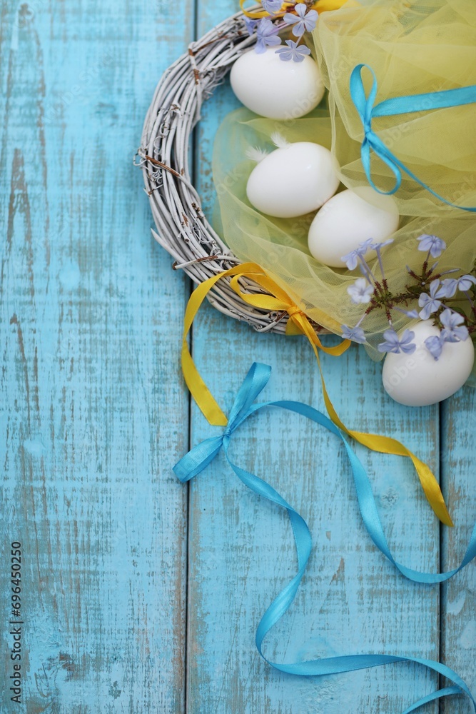 Eggs on the table, Easter, holiday, greetings, day, blue and yellow ribbons, blue wooden background, top view, free space, place for text Eggs on the table, Easter, holiday, greetings, day, blue and yellow ribbons, blue wooden background, top view, free space, place for text