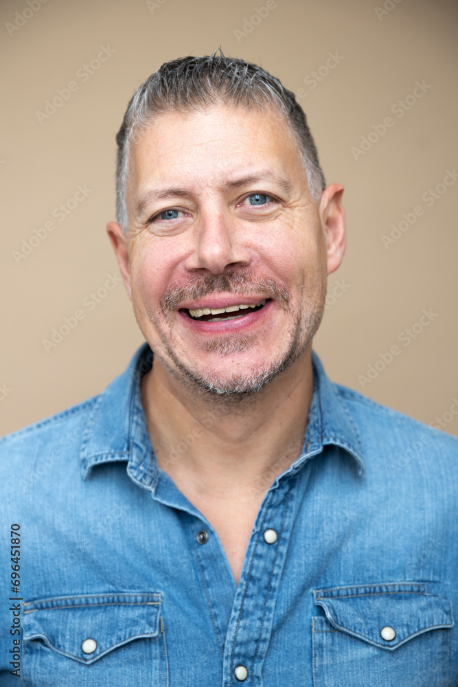 cool man, 46 age, with grey hair, blue jeans, blue shirt, posing in front of brown studio, portrait, concept, business, casual cool man, 46 age, with grey hair, blue jeans, blue shirt, posing in front of brown studio, portrait, concept, business, casual
