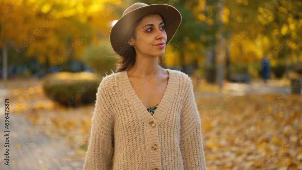 joyful smiling woman wearing long knitted sweater or cardigan walks in maple park with golden foliage. Woman in nature at warm fall day. Active lifestyle. Female outdoors. girl walk in autumn park joyful smiling woman wearing long knitted sweater or cardigan walks in maple park with golden foliage. Woman in nature at warm fall day. Active lifestyle. Female outdoors. girl walk in autumn park