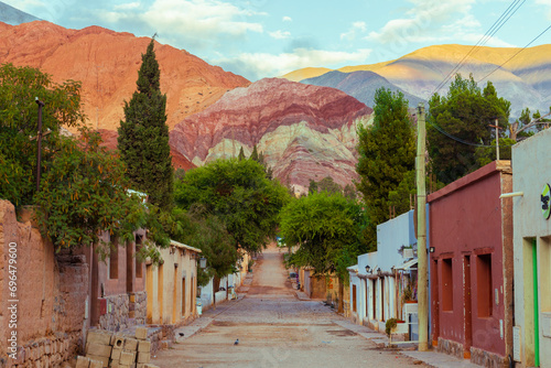 Incredible shot of a lonely street in the city of Purmamarca, Argentina with the hill of seven colors in the background photo