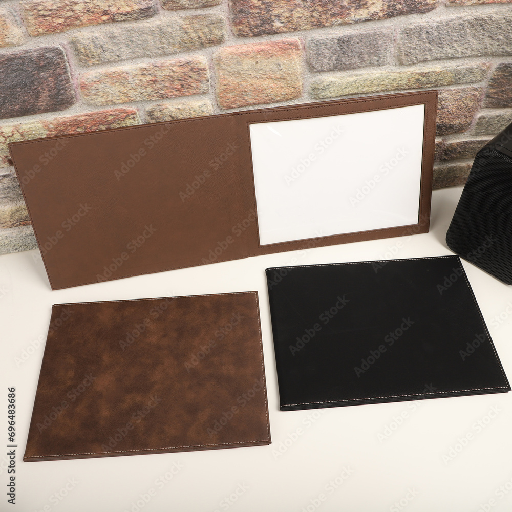 Fototapeta premium Colorful leather diploma holder. Concept shot, top view, different color, clamshell and stitched diploma holder, A new leather award board certificate and diploma frame