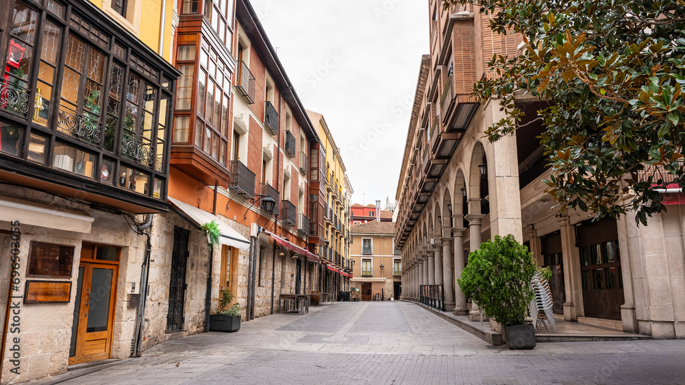 Picturesque street in the city of Valladolid with arcades in historic buildings, Spain. - obrazy, fototapety, plakaty 