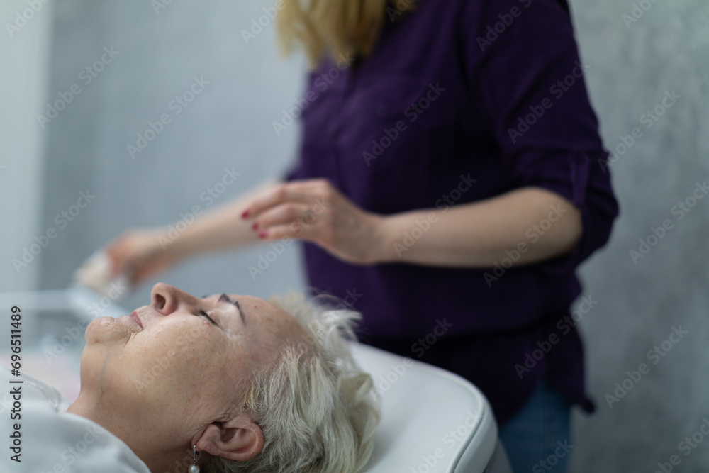 An elderly woman lies on a comfortable bed in a beauty salon An elderly woman lies on a comfortable bed in a beauty salon