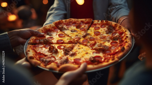 Close-up of people picking up pieces of pizza at outside party. Friendship and family concept