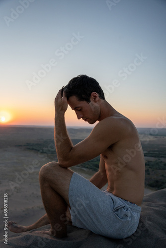 Man sitting on top of Bruneau Sand Dune at Sunset in Idaho.  The tallest sand dunes in North America located in the western part of the United States.  Person enjoying the view during a sunset. photo